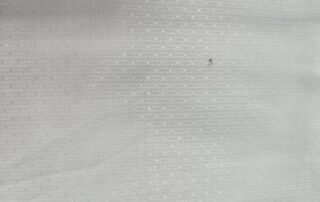 Close-up of pigment spots on a light-colored fabric after heat-setting